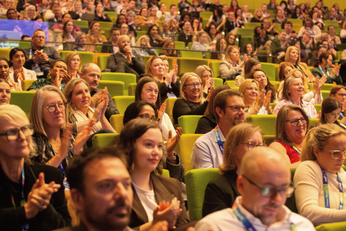 A large crowd claps for keynote speaker